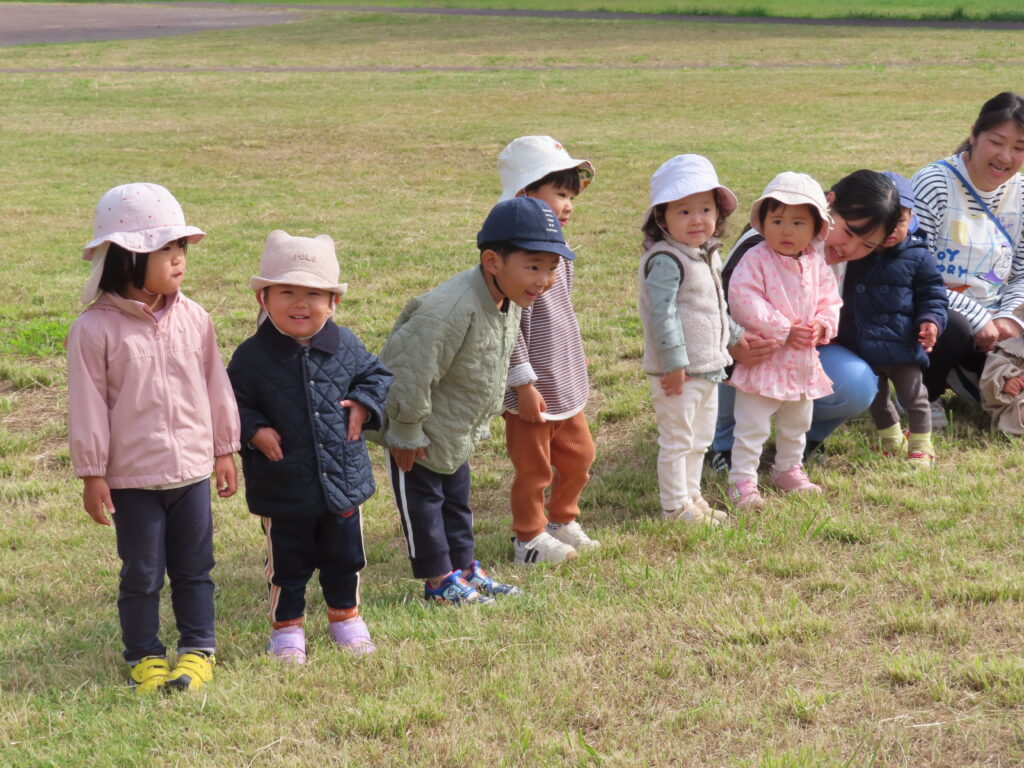 <p>親子行事「原っぱであそぼう!」開催しました!</p>
<p>いつものお散歩に出発すると、東屋にお父さんお母さんが待っていてくれて!嬉しい子ども達♥</p>
<p>みんなで踊ったり、かけっこをしたり、カブになって抜かれたり‼「あはは!うふふ!」とたくさんの笑顔が見られました。</p>
<p>子ども達だけじゃなく保護者の方々にもかけっこやパン食い競争など楽しんでもらえたかな⁉と思っています☆</p>
<p>秋空の下、みんなで楽しい時間をすごせました!</p>
写真2